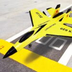 Fusée de modélisme militaire jaune et noire avec marquages "CHINA AIR FORCE" et "SU-35" sur une piste d'atterrissage.