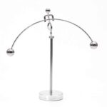 Péndule de Newton en métal brillant avec sphères suspendues, illustrant la conservation de la quantité de mouvement et l'énergie cinétique.