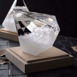 Cube en verre transparent contenant un liquide clair, posé sur une base en bois, idéal pour la décoration de style scientifique ou contemporain.