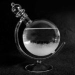 Bouteille de laboratoire en verre contenant un liquide clair avec fumée blanche, utilisée pour la décoration scientifique ou expérimentale.