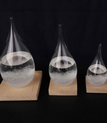 Pipettes en verre contenant un liquide transparent, disposées sur des supports en bois de différentes tailles, illustrant un phénomène scientifique ou une expérience de laboratoire.
