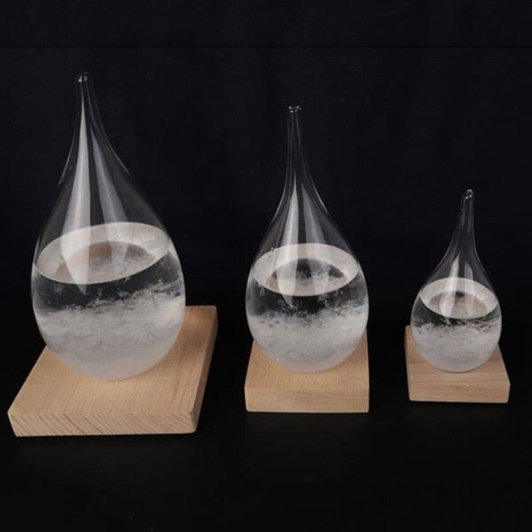 Pipettes en verre contenant un liquide transparent, disposées sur des supports en bois de différentes tailles, illustrant un phénomène scientifique ou une expérience de laboratoire.
