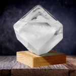 Cube de glace transparent en forme de diamant posé sur un socle en bois, idéal pour la décoration de laboratoire ou d'espace scientifique contemporain.