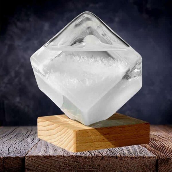 Cube de glace transparent en forme de diamant posé sur un socle en bois, idéal pour la décoration de laboratoire ou d'espace scientifique contemporain.
