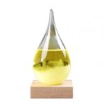 Vase en verre contenant un liquide jaune lumineux, posé sur une base en bois, parfait pour la décoration scientifique ou moderne.