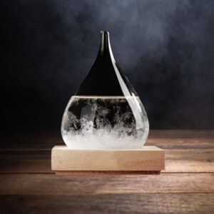 Vase en verre contenant un liquide clair avec des bulles, posé sur une base en bois, avec un fond sombre.