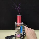 Miniature bobine Tesla avec étincelles violettes, éclairage LED et composants électroniques visibles.