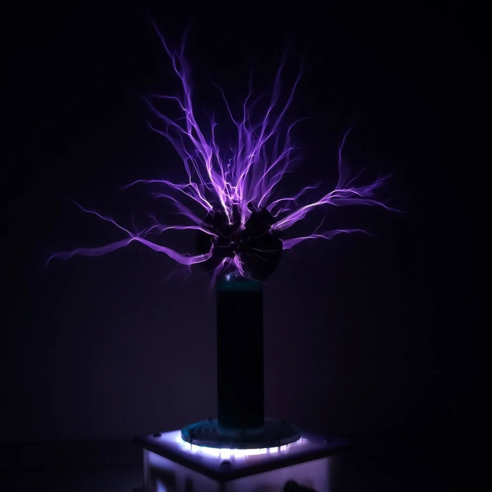 Illustration d'une décharge électrique statique violette émanant d'une sphère, exposée dans un environnement sombre, représentant une expérience scientifique ou un phénomène électrique.