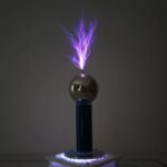 Boule de Tesla en verre avec décharge électrique violette, illustrant un phénomène scientifique fascinant.