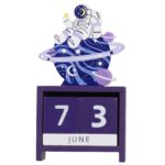 Panneau calendrier en bois avec illustration d’un astronaute flottant dans l’espace.