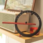 Horloge scientifique avec règle intégrée, affichant les mois de l'année, utilisée comme décoration de bureau ou d'étude pour un style moderne et éducatif.