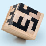 Puzzle en bois avec motifs géométriques noirs et naturels, parfait pour la décoration scientifique ou comme objet de jeu éducatif.