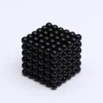 Billes magnétiques noires formant une pyramide 3D, utilisées pour la décoration ou la science.