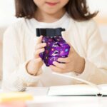 Jeune enfant tenant un cube scientifique coloré, illustrant la curiosité et l'apprentissage en sciences pour les jeunes.