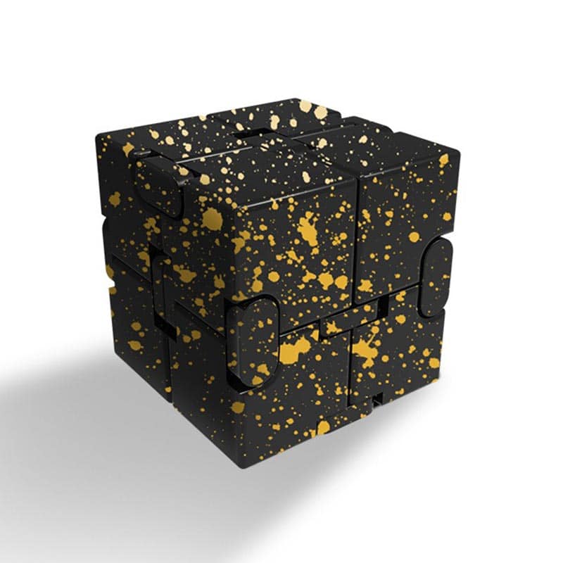 Éclaboussures dorées sur un cube puzzle noir, décoration moderne et originale.
