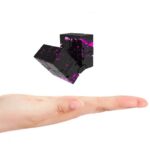 Puzzle cube en lévitation avec effets de peinture rose sur fond blanc.