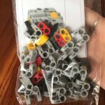 Puce de construction scientifique en plastique gris, rouge, jaune et noir, idéale pour projets éducatifs et expérimentations scientifiques, facile à assembler.