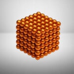 Bille en métal orange brillant formant une pyramide 3D, illustrant un modèle scientifique ou décoratif.