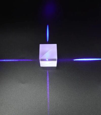 Porte-laser en verre transparent avec lumière bleue, projetant des lignes lumineuses sur une surface noire, créant un effet visuel futuriste et scientifique.