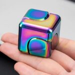 Cube métallique irisé aux couleurs arc-en-ciel, design contemporain, parfait pour la décoration scientifique ou comme objet de collection.