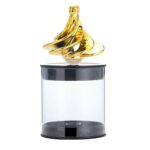 Flacon de parfum décoratif en forme de spirale dorée, posé sur un socle transparent, alliant design scientifique et élégance luxueuse.