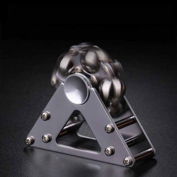 Pyramide de balles métalliques en équilibre sur une base en métal, illustrant un phénomène physique ou une expérience scientifique.