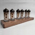 Nixie tubes vintage affichant des chiffres sur un support en bois, parfaits pour décoration scientifique ou rétro.