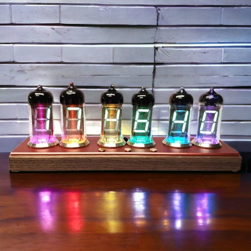 Nombres lumineux en verre coloré affichant les chiffres 1, 2, 3, 4, 5 et 6, posés sur un support en bois, avec un fond en briques blanches.