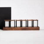 Ensemble de six boîtes en verre avec couvercles en bois, disposées sur une base en bois, parfaites pour la décoration ou la présentation d'objets scientifiques.