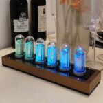 Nombres lumineux Nixie tubes affichant "2024" avec bouteilles de vin en arrière-plan, décoration moderne et technologique pour intérieur élégant.