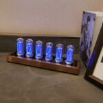 Horloge Nixie avec tubes lumineux affichant les chiffres 1, 2, 0, 4, 0, 4, sur une base en bois, décoratif et rétro, idéale pour la décoration de bureau ou salon.