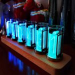 Panneau lumineux avec chiffres premiers en tubes LED bleus sur support en bois, décoration moderne et scientifique.
