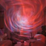 Vortex cosmique lumineux projeté sur un mur intérieur, créant un effet visuel hypnotique avec des couleurs chaudes et froides. Parfait pour une décoration d'intérieur inspirée de l'univers et de la sc.