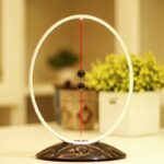 Balle de Newton avec cadre lumineux, expérience scientifique pour démonstration de la loi de la conservation du mouvement, décoration éducative moderne.