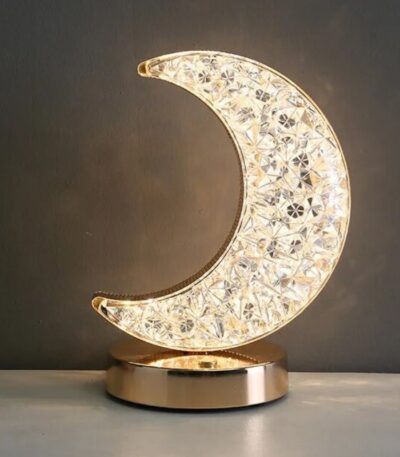 L'ampoule en forme de lune en cristal, élégante et raffinée, repose sur une base en métal doré, idéale pour une décoration de style scientifique ou moderne.