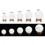 Lampe lunaire en différentes tailles avec support en bois, allant de 8 cm à 18 cm, idéale pour décoration intérieure ou comme lampe d'ambiance.