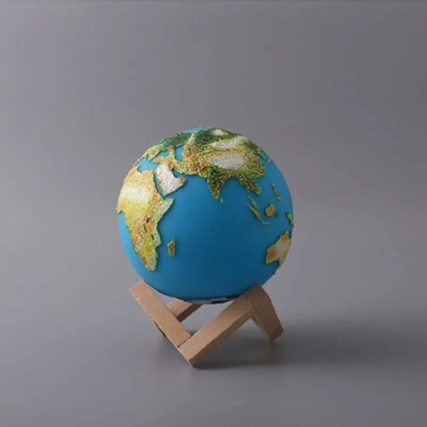 Terre miniature avec continents en relief, sur support en bois, utilisé comme objet décoratif ou éducatif.