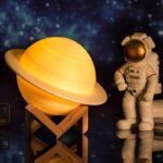 Lampe Saturne en décoration avec figurine d'astronaute, ambiance spatiale, idéal pour décoration scientifique et éducative.