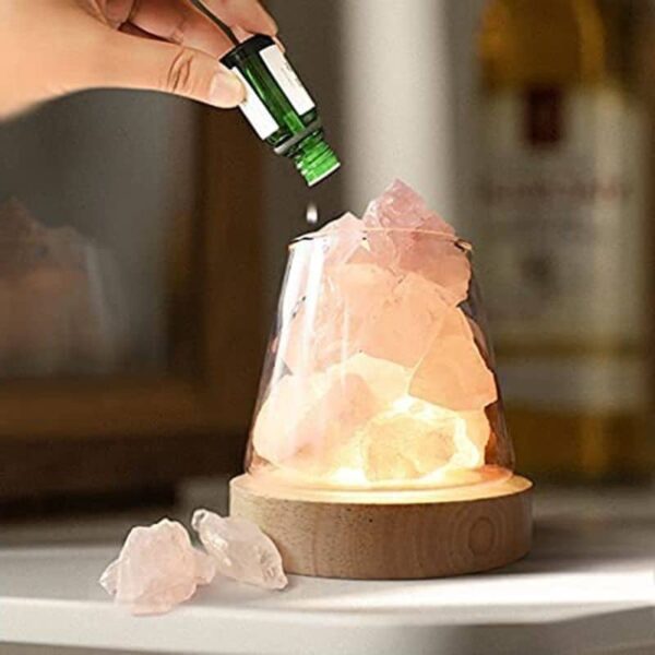 Pyramide de cristaux de sel rose avec flacon d'huile essentielle, décoration de science pour la maison ou le bureau.