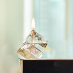 Porte-encens en forme de cube en verre avec flamme allumée, idéal pour la décoration scientifique et moderne.