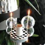 Bougie globe en verre avec tasse de café sur une table.
