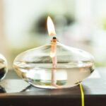 Ampoule de cire en verre avec flamme allumée, idéale pour décoration scientifique ou ambiance chaleureuse.