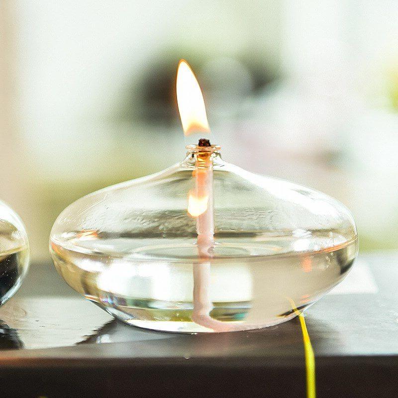 Ampoule de cire en verre avec flamme allumée, idéale pour décoration scientifique ou ambiance chaleureuse.