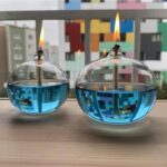 Bougie décorative en forme de flamme avec liquide bleu et flamme artificielle.