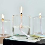 Bougie scientifique avec mèche en forme de spirale allumée dans un récipient en verre, décorant un espace de science et de décoration.