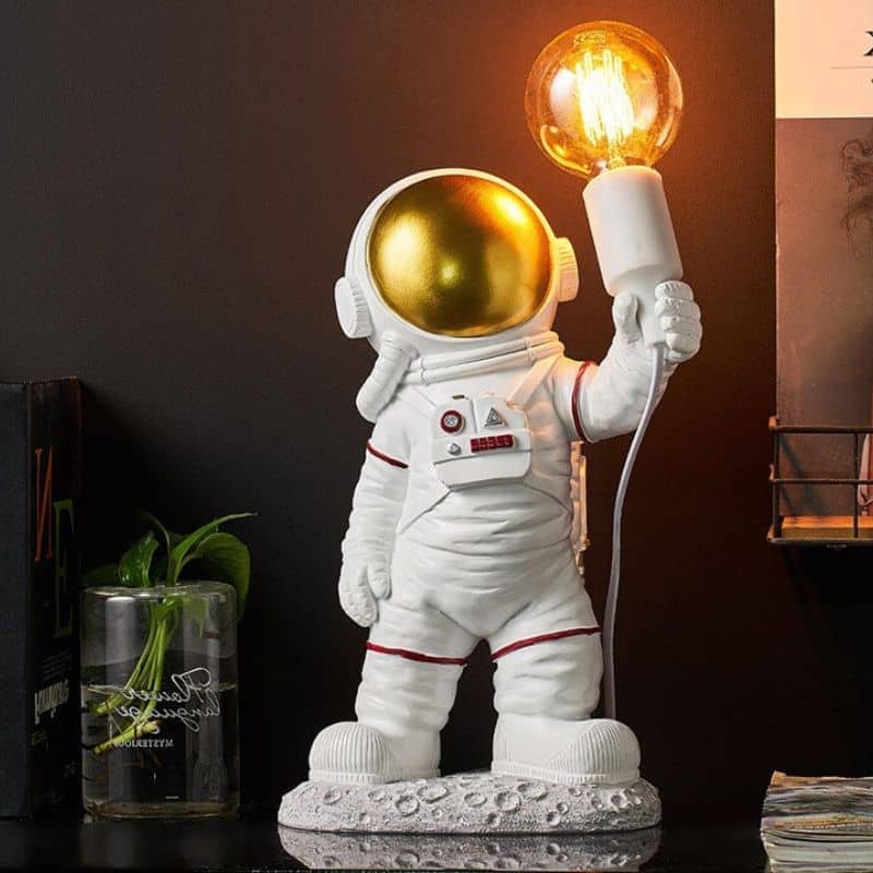 Figurine d'astronaute décorative avec lampe à ampoule vintage, idéale pour la décoration intérieure thématique spatiale ou scientifique.