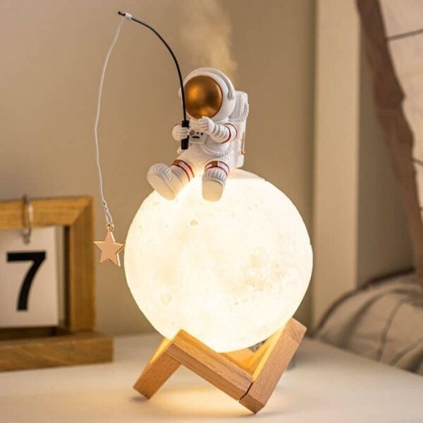 Lampe de nuit lune avec figurine d'astronaute et poisson rouge en verre.