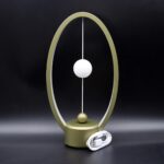 Lampe de décoration scientifique moderne avec cercle doré et boule blanche, idéale pour un intérieur élégant et original.