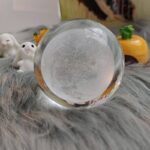 Boule de cristal transparente avec effets de gel à l'intérieur, idéale pour la décoration scientifique ou comme objet de collection.