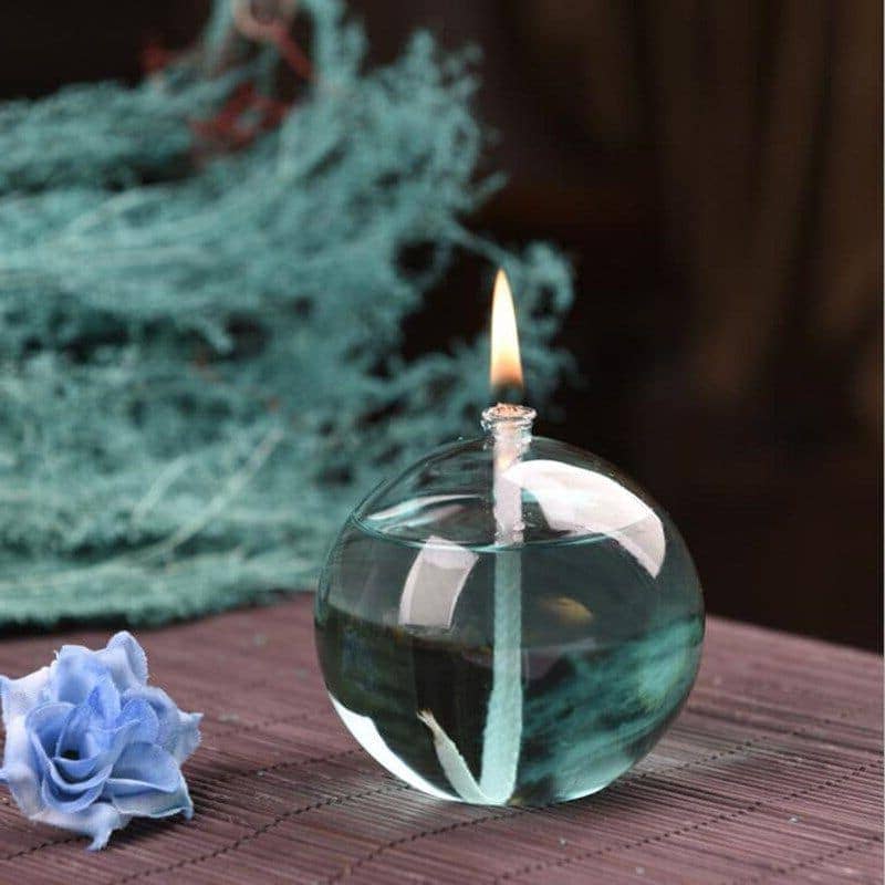 Bougie flottante dans une boule de verre avec flamme allumée, décoration élégante et moderne.